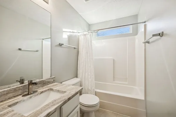 a bathroom with a granite countertop sink toilet and shower