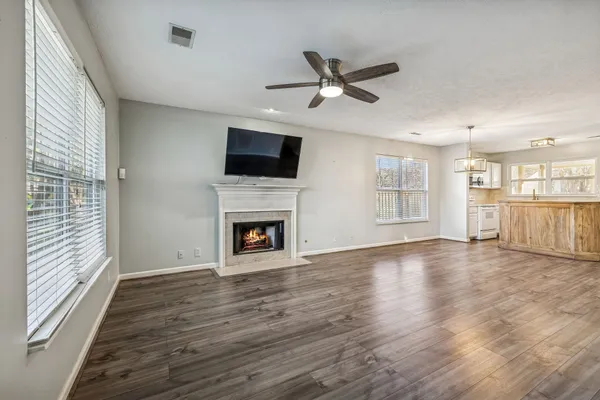 a view of a livingroom with a fireplace wooden floor and windows