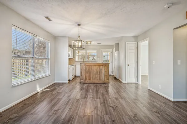 a view of empty room with wooden floor and window