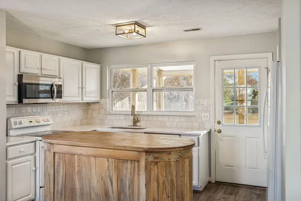 a kitchen with stainless steel appliances granite countertop a sink a stove and a microwave