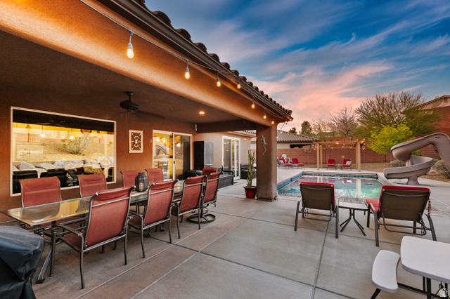 210 Talon Court Ivins, UT 84738 - Photo 45 of 60 Patio terrace at dusk with outdoor dining area, a patio area, ceiling fan, a fenced backyard, and a pergola