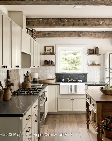 a kitchen with a stove a table and chairs in it