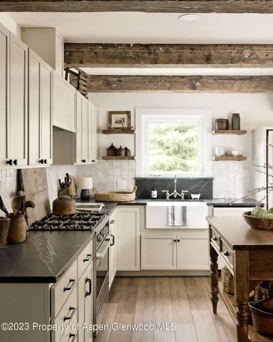 a kitchen with a stove a table and chairs in it