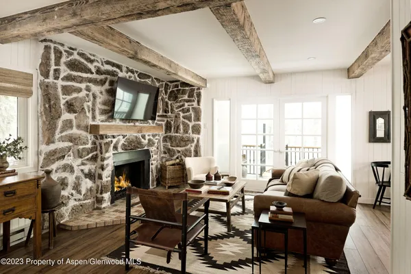 a living room with furniture a fireplace and a floor to ceiling window