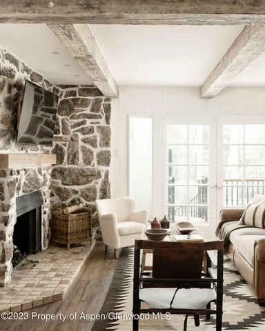 a living room with furniture a fireplace and a chandelier