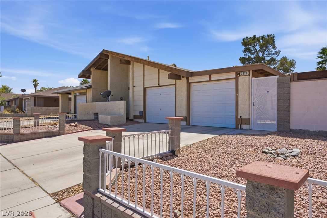 3971 Spring Leaf Drive Las Vegas, NV 89147 - Photo 7 of 48 A well-maintained stucco home with a double garage and secured entry, offering desert landscaping.