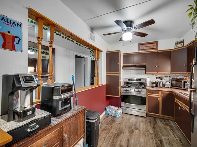 a kitchen with stainless steel appliances a stove a refrigerator and wooden cabinets