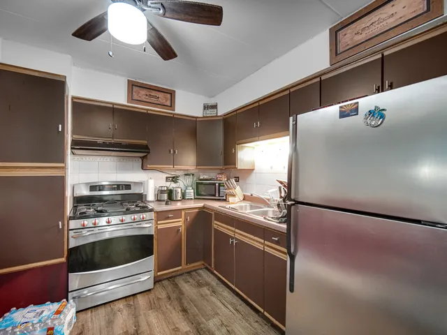 a kitchen with stainless steel appliances a stove a sink and cabinets