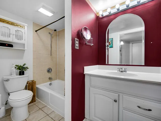 a bathroom with a bathtub sink mirror vanity and toilet