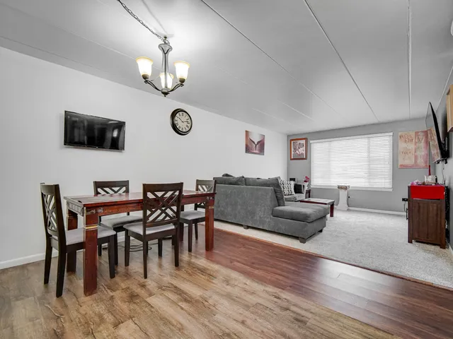 a living room with furniture a flat screen tv and kitchen view