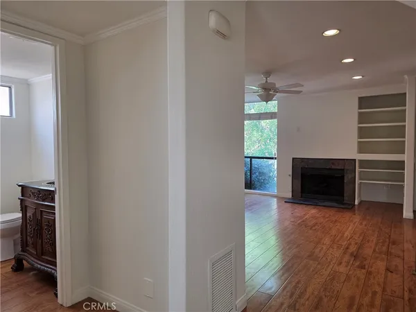 a view of a hallway with wooden floor and a fireplace
