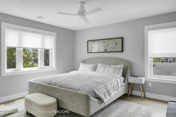 a bedroom with a bed and a window with chair