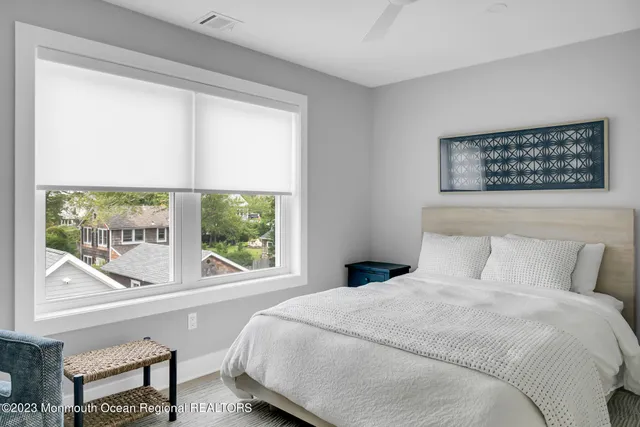 a bedroom with a bed and a large window
