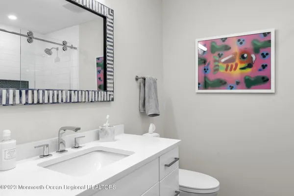 a bathroom with a sink mirror vanity and toilet