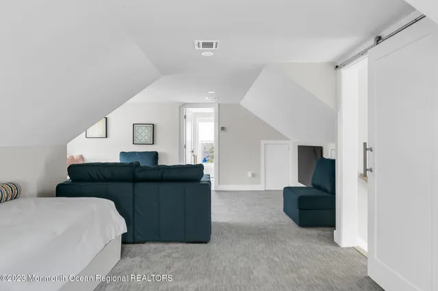 a living room with furniture and a refrigerator