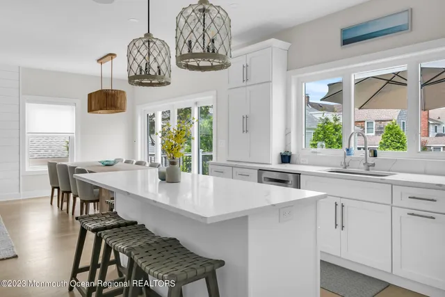 a kitchen with stainless steel appliances a table and chairs in it