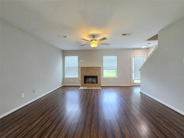 a view of an empty room with a fireplace and a window