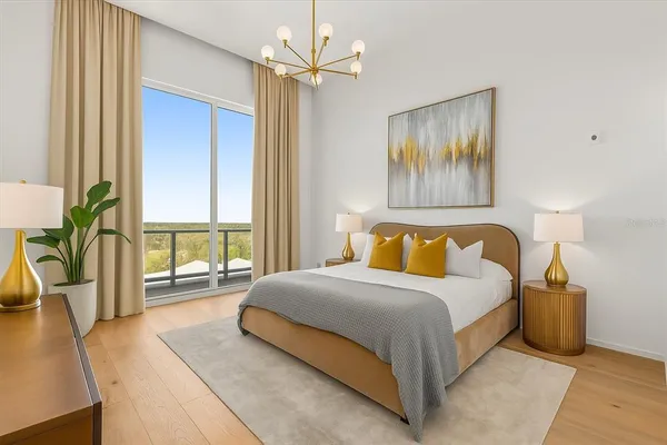 a bedroom with a large bed and a chandelier