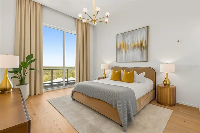 a bedroom with a large bed and a chandelier