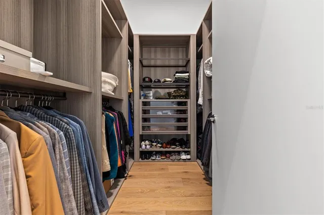 a view of walk in closet with clothes and shoes