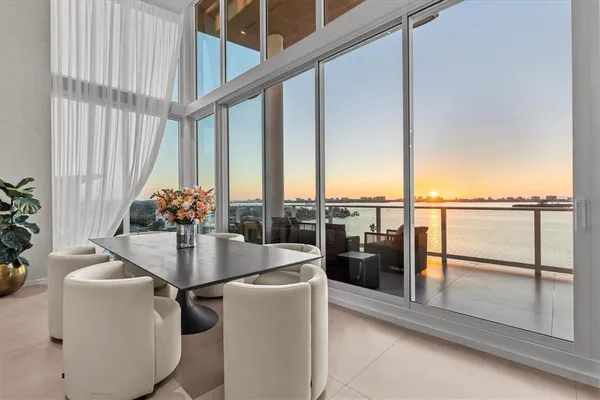 a dining room with furniture and large windows