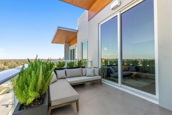 a balcony with couch and a potted plant