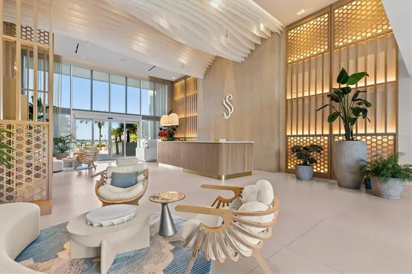 a living room with patio furniture and a potted plant