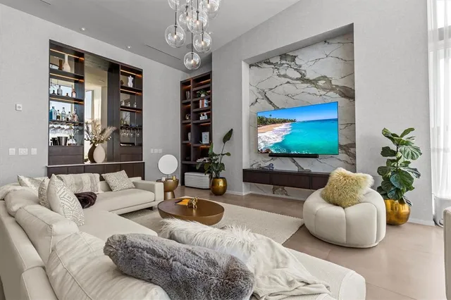 a living room with furniture a chandelier and a flat screen tv