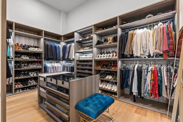 a view of walk in closet with clothes and shoes