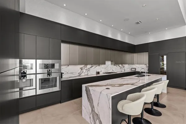 a kitchen with stainless steel appliances kitchen island granite countertop a stove a sink a refrigerator and island with wooden floor