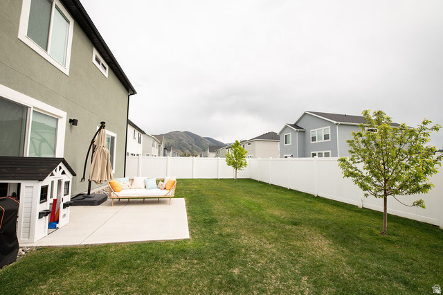 384 Ropelato Drive Nibley, UT 84321 - Photo 18 of 25 Expansive backyard featuring a concrete patio, a manicured lawn, and a white privacy fence