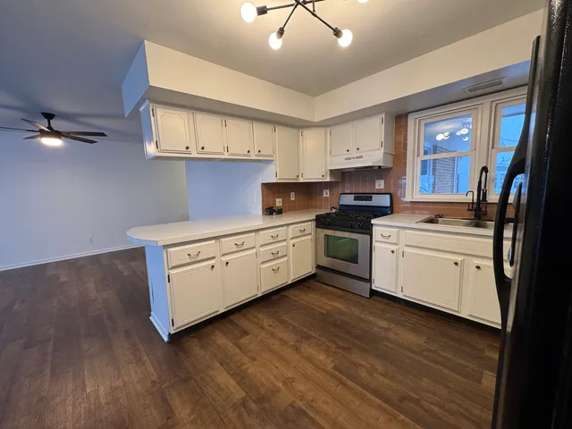 a kitchen with stainless steel appliances a white stove top oven sink and cabinets