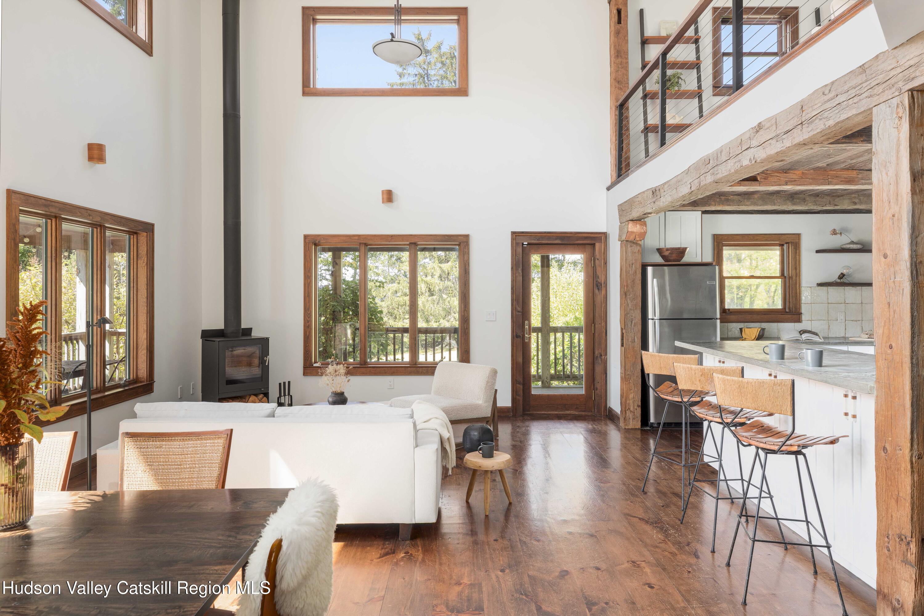 396 Doig Hollow Road Bovina, NY 13731 - Photo 16 of 44 a living room with furniture wooden floor and a large window