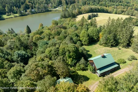 an aerial view of a house with a yard and lake view