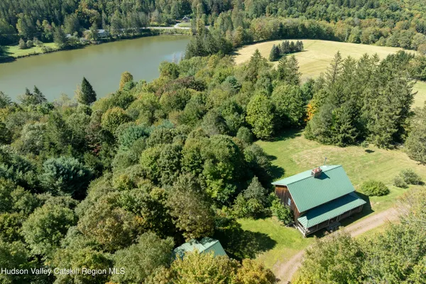 an aerial view of a house with a yard and lake view