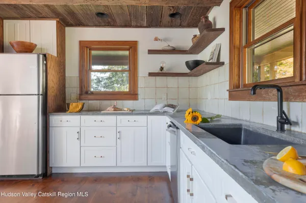 a kitchen with stainless steel appliances granite countertop a sink a stove and a refrigerator