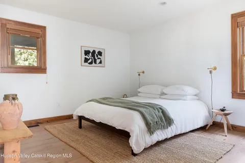 a bedroom with a bed and painting on the wall