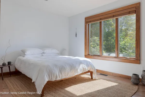 a bedroom with a bed and a large window