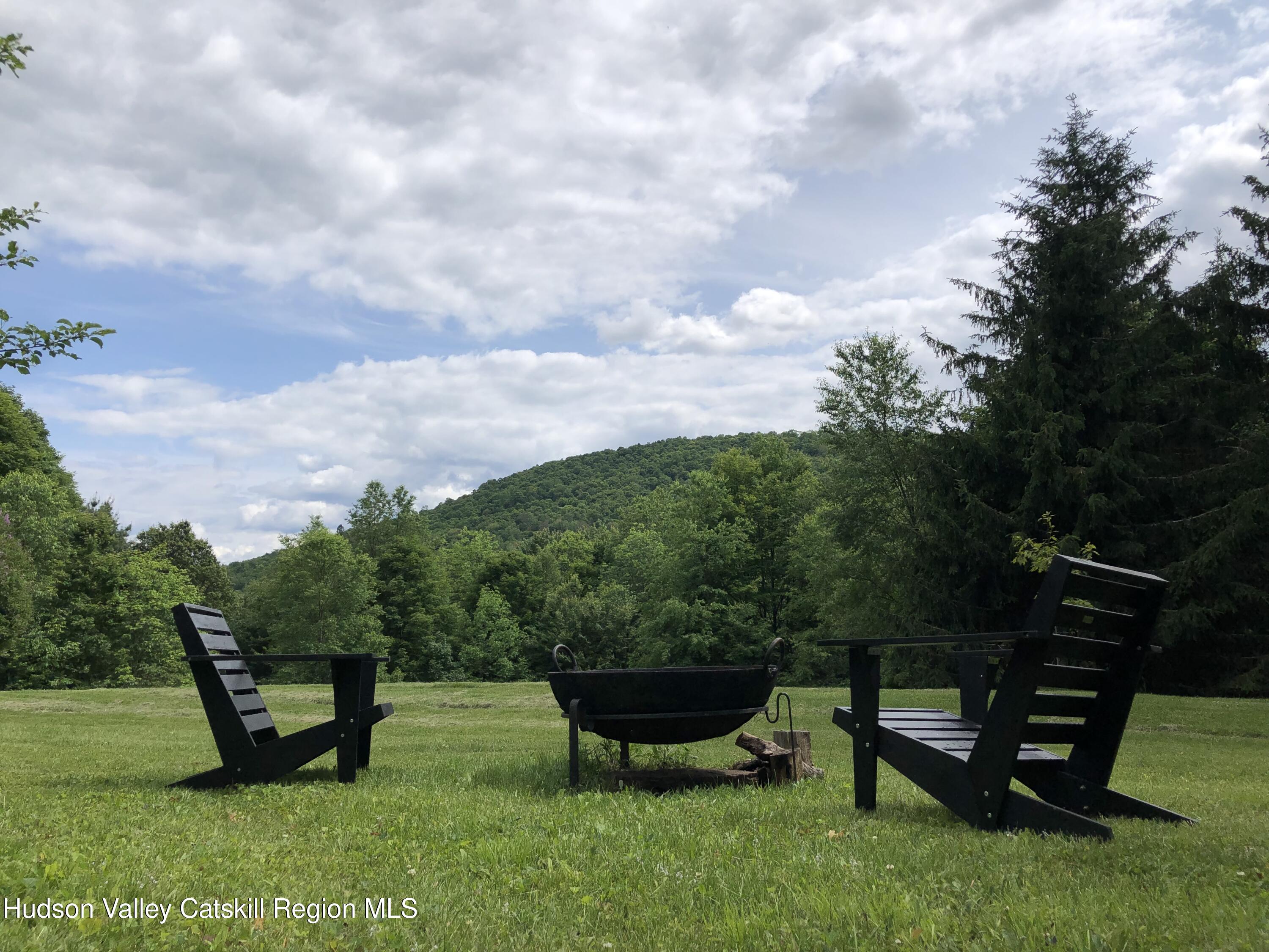 396 Doig Hollow Road Bovina, NY 13731 - Photo 43 of 44 a view of a bench in the garden near a lake