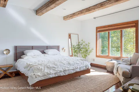 a bedroom with bed couch and window