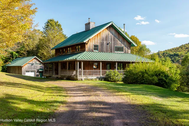 a front view of a house with yard and green space