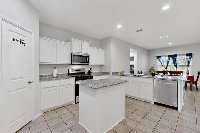 a kitchen with white cabinets stainless steel appliances and sink