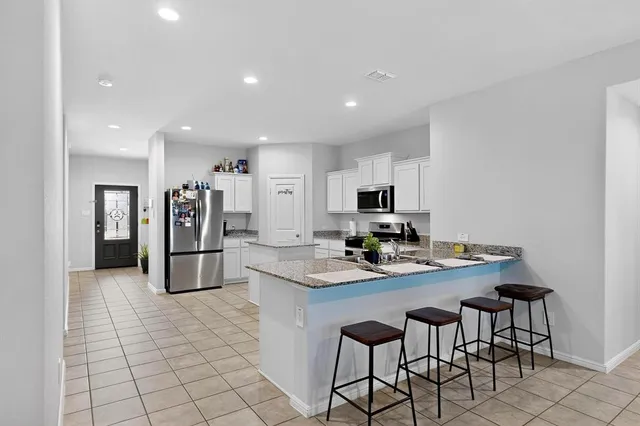a kitchen with stainless steel appliances kitchen island granite countertop a sink and cabinets