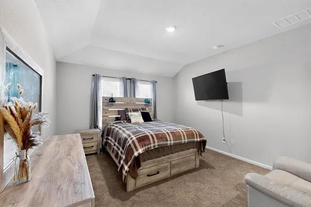 a bedroom with a bed and a flat screen tv