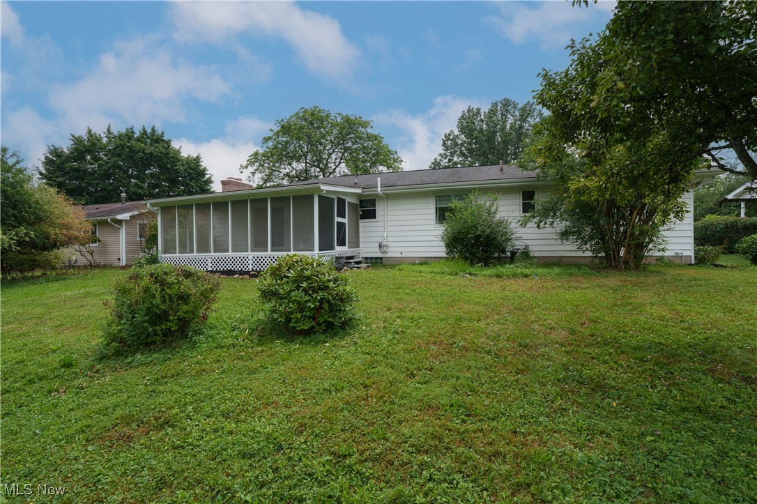 2783 Shellhart Road Barberton, OH 44203 - Photo 2 of 24 Back of house with a sunroom, a lawn, and a chimney