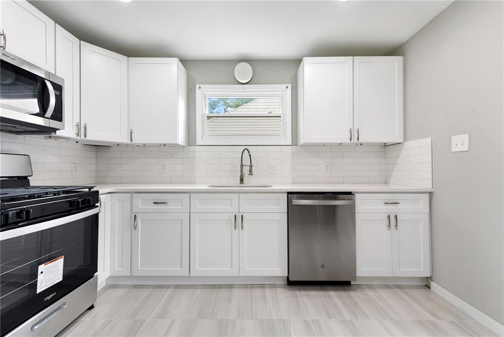 614 Springdale Drive Pittsburgh, PA 15235 - Photo 11 of 31 a kitchen with granite countertop white cabinets stainless steel appliances and sink