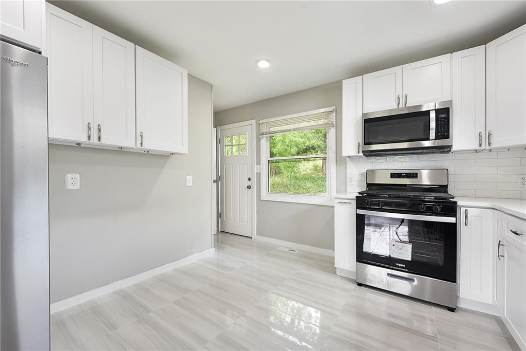614 Springdale Drive Pittsburgh, PA 15235 - Photo 14 of 31 a kitchen with granite countertop a stove a microwave and a sink