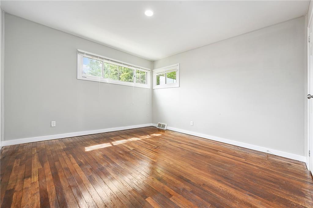 614 Springdale Drive Pittsburgh, PA 15235 - Photo 17 of 31 a view of an empty room with wooden floor and a window