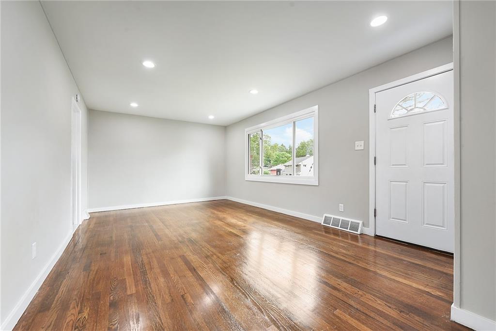 614 Springdale Drive Pittsburgh, PA 15235 - Photo 4 of 31 an empty room with wooden floor and windows