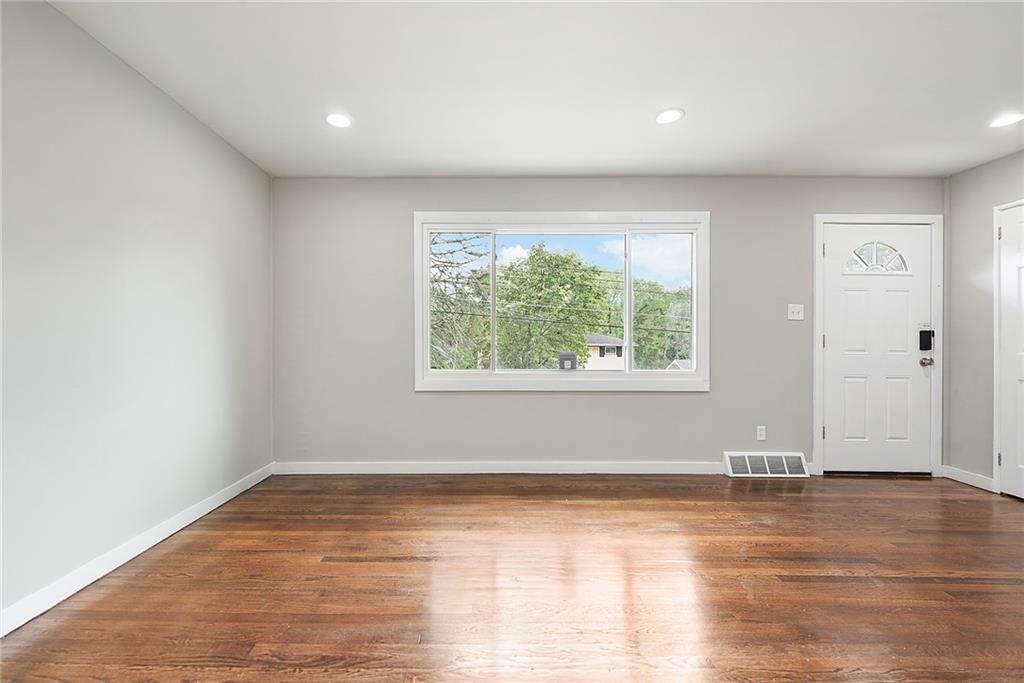 614 Springdale Drive Pittsburgh, PA 15235 - Photo 8 of 31 an empty room with wooden floor and windows